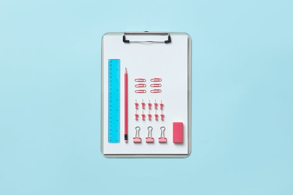 Neatly arranged office supplies on clipboard creating an organized flat lay.